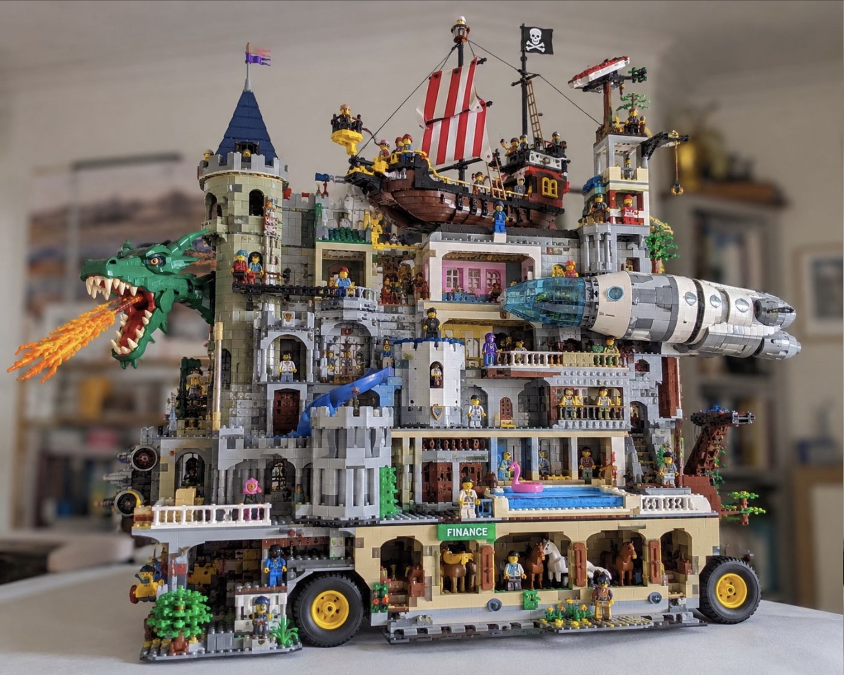 An over-the-top Lego build: a castle on wheels with a fire-breathing dragon, a pirate ship on the roof, a spaceship tower, a swimming pool — and a Finance floor full of horses.